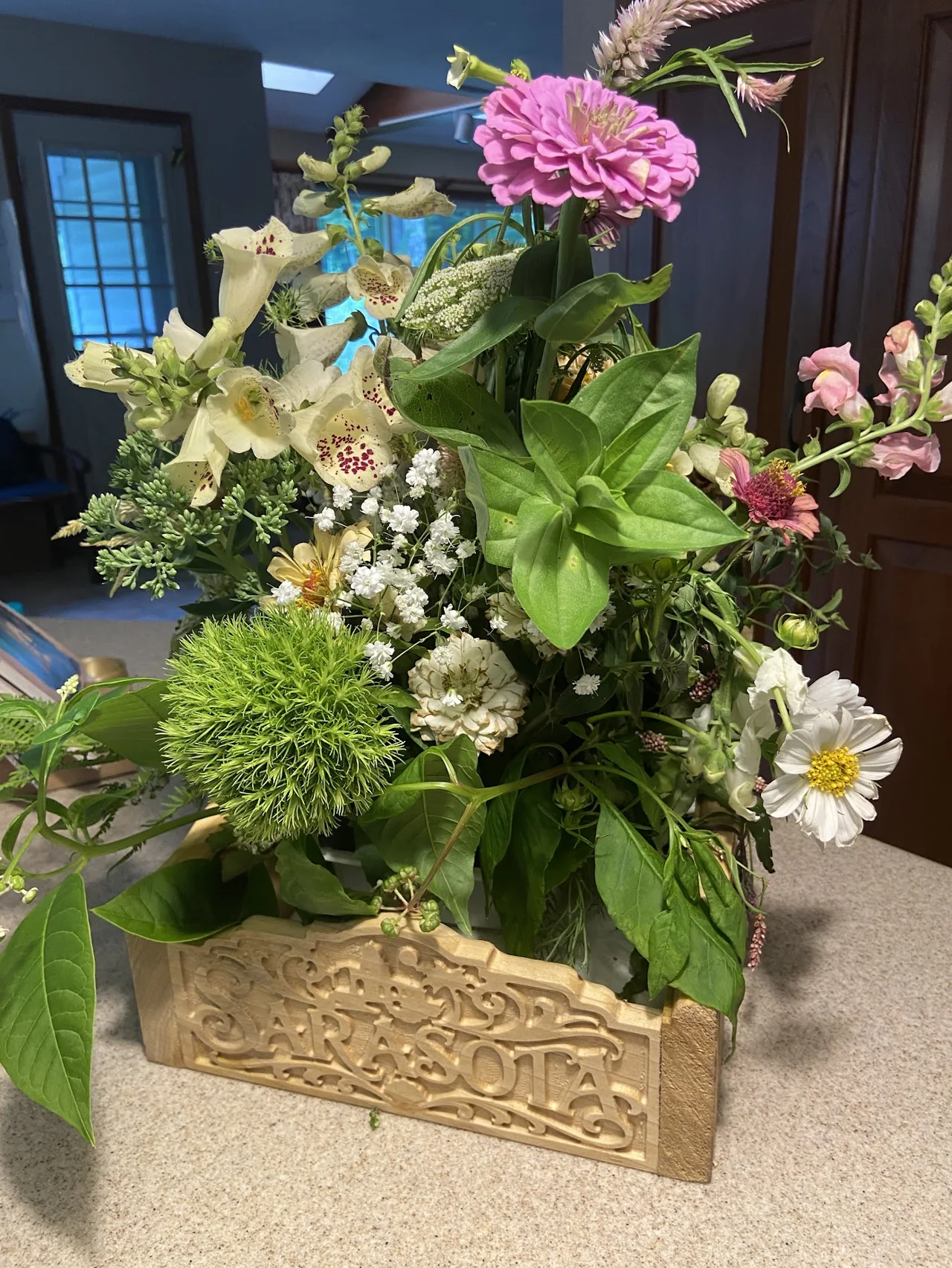 CNC-carved wood centerpiece with ornate relief and fresh flowers
