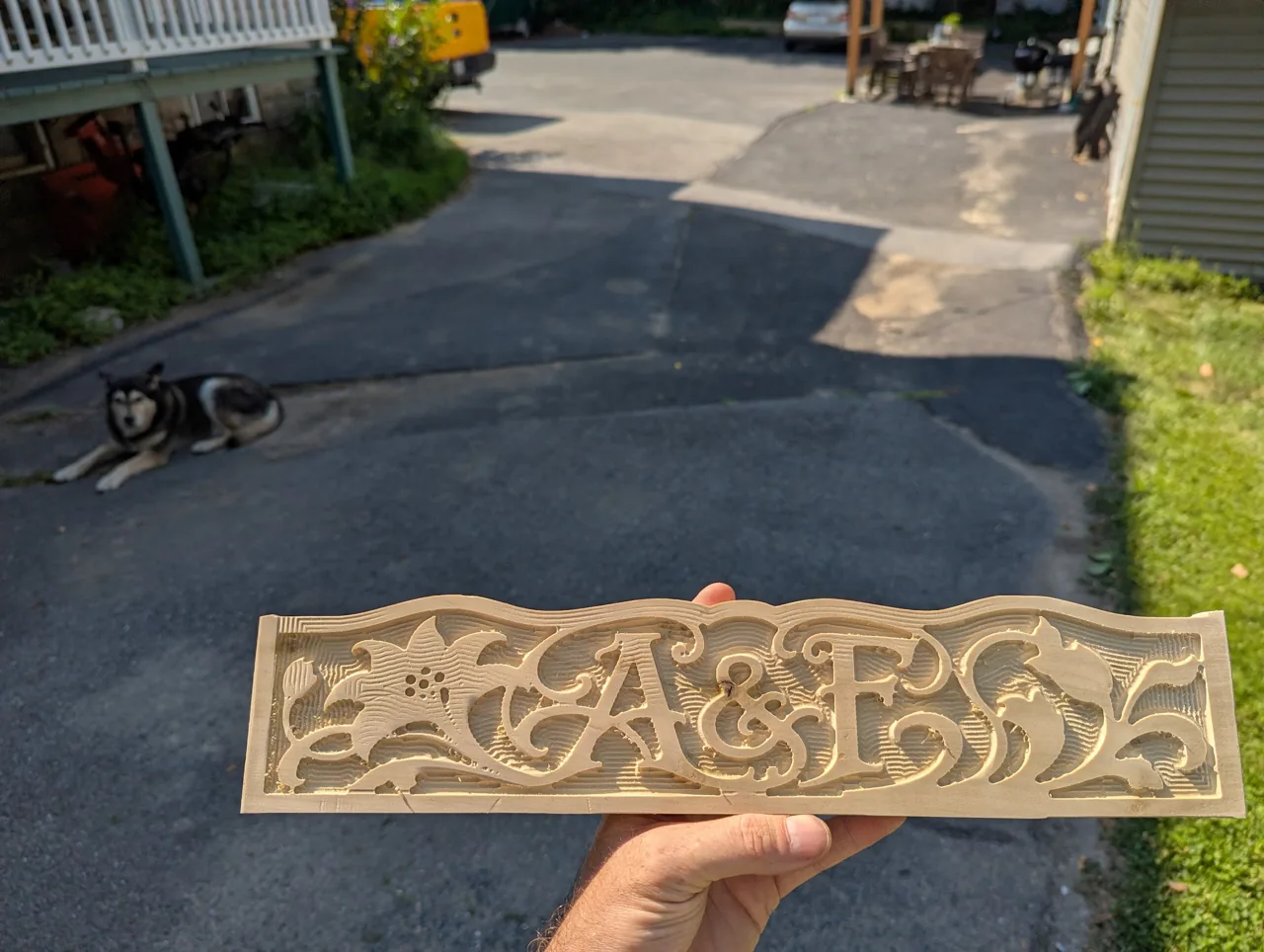 An intricately CNC-carved wood panel with a custom wedding monogram