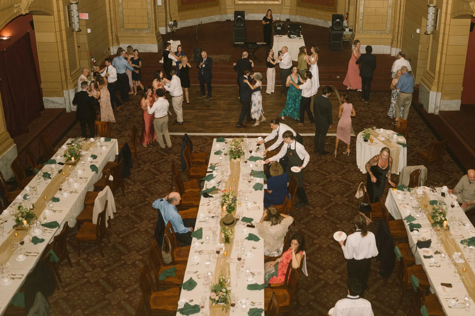 Wedding guests celebrating among tables with custom centerpiece boxes